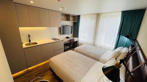 um quarto de hotel com duas camas e uma cozinha em Grace Chapinero em Bogotá