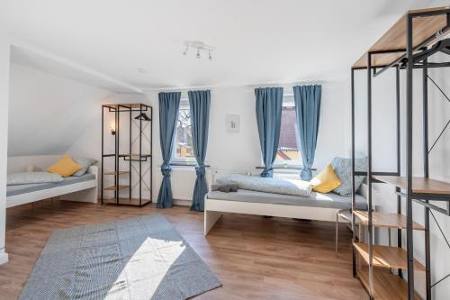 a bedroom with two beds and blue curtains at 1890 Apartments Bayreuth in Bayreuth