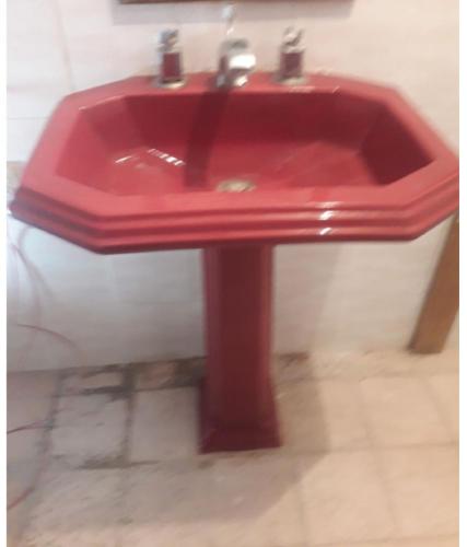 a red sink in a bathroom with at La Habitacion. in Celaya