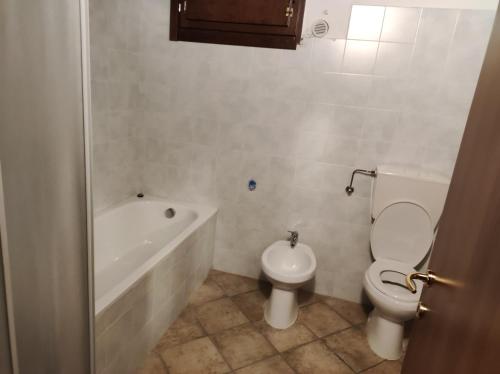 a bathroom with a toilet and a tub and a sink at La Corte dei Celti in San Benedetto Del Querceto