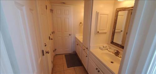 a white bathroom with a sink and a mirror at Saida I Condos S1206 in South Padre Island