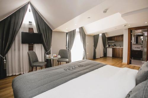 イスタンブールにあるBeyzas Hotels & Suitesのベッドとキッチン付きのホテルルーム