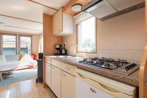 a kitchen with a sink and a stove top oven at Heidehut in Midsland