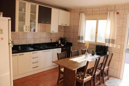 a kitchen with a table and chairs and a refrigerator at Pousada paraíso in Bento Gonçalves