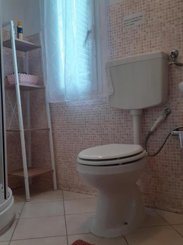 bagno con servizi igienici bianchi e finestra di La Casa dei Nonni ad Arezzo