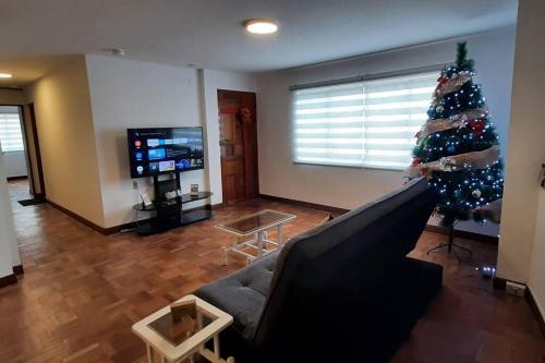una sala de estar con un árbol de Navidad y un sofá en Acogedor apartamento cerca del teleférico amarillo, en La Paz