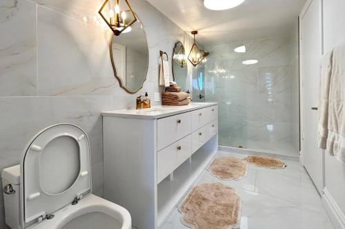 La salle de bains est pourvue de toilettes, d'un lavabo et d'un miroir. dans l'établissement Iconbrickell Residences by Fonte Vacation Rentals, à Miami