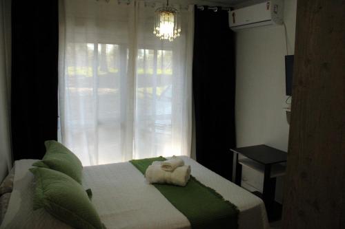 Un dormitorio con una cama con una toalla. en Pousada paraíso, en Bento Gonçalves