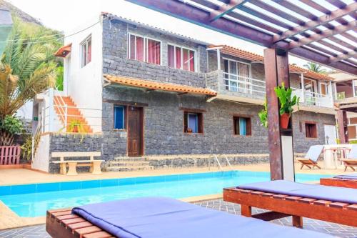 a villa with a swimming pool and a house at Pousada Quinta Ribeirinha in Cidade Velha
