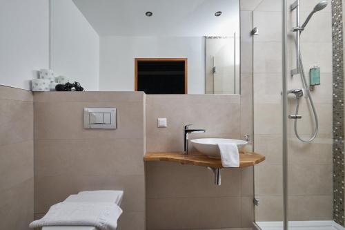 W łazience znajduje się umywalka i prysznic. w obiekcie Boutique Pałac Warmątowice Sienkiewiczowskie w mieście Legnica