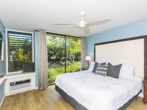 a bedroom with a bed and a large window at The Luau Lounge at Turtle Bay with pool in Kahuku