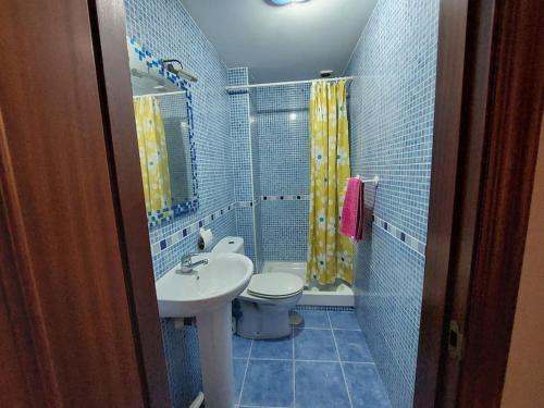 uma casa de banho azul com um lavatório e um WC em Piso céntrico de dos dormitorios em La Línea de la Concepción