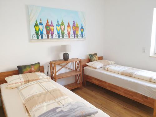 dwa łóżka w pokoju z obrazem na ścianie w obiekcie Ferienwohnung Zur Flatter-Ulme w mieście Weißwasser