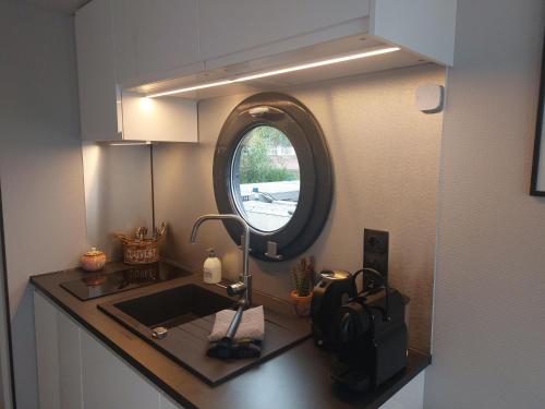 a kitchen with a sink and a round window at Modern Holiday Home in Molina di Ledro with Terrace in Volendam