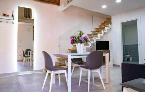 una sala da pranzo con tavolo e sedie bianchi di SANT'ANTIDA HOME a Caserta