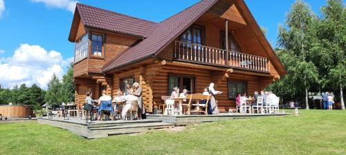 a group of people standing in front of a log cabin at Meijas Nams in Kalupe