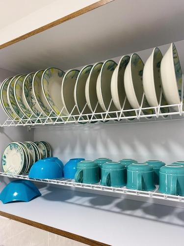 a bunch of plates and bowls on a shelf at Jardín de Primavera Apartamentos in Jardin