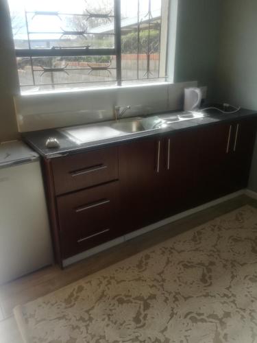 a kitchen with a sink and a window at Maseru Home with a View in Maseru