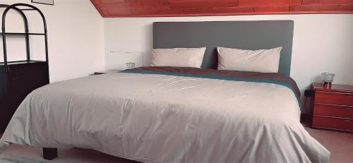 1 dormitorio con 1 cama grande con sábanas blancas en Ferienwohnung Bleialf, en Bleialf