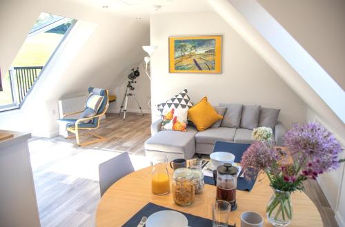 a living room with a couch and a table at The Roost - a bird's eye view in the countryside in Cullompton