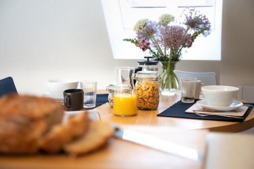 a table with food and a vase of flowers at The Roost - a bird's eye view in the countryside in Cullompton