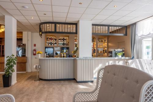 a bar in a restaurant with two chairs at Mediteran Maradiso Hotel by Aminess in Crikvenica
