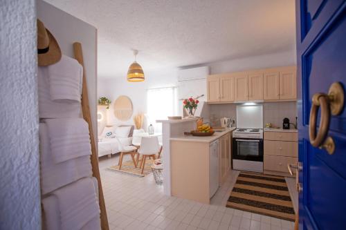 een keuken met witte apparatuur en een woonkamer bij Hidden Serenity in Mykonos-stad
