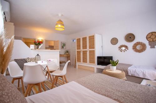 een woonkamer met een tafel en stoelen en een keuken bij Hidden Serenity in Mykonos-stad