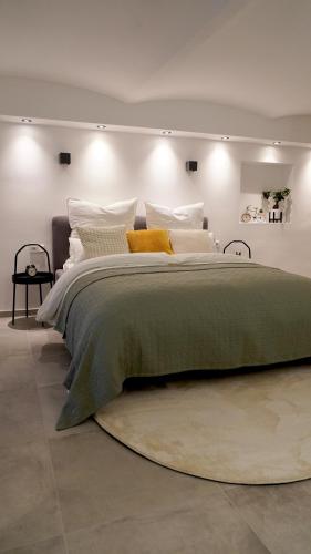 a large bed with a green blanket and pillows at Luxuriöse Stadtvilla im Hansaviertel in Wuppertal