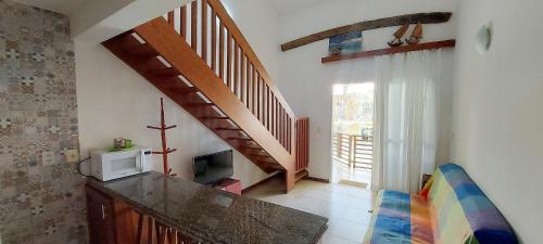 a living room with a staircase and a microwave at COARE0100 - Condominio Aldeia Saint Sebastien in Arembepe