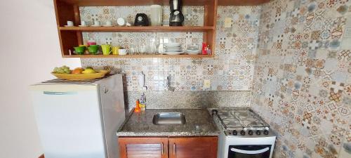 a small kitchen with a stove and a refrigerator at COARE0100 - Condominio Aldeia Saint Sebastien in Arembepe
