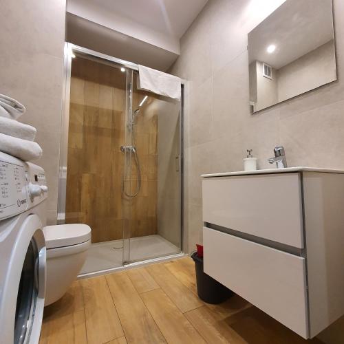 a bathroom with a shower and a toilet and a sink at Apartament Holiday B 210 in Pobierowo