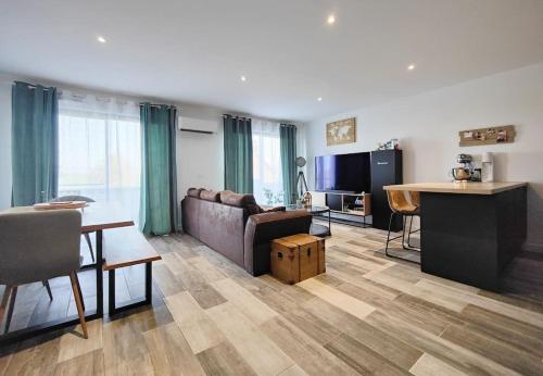 ein Wohnzimmer mit einem Sofa und einem Tisch in der Unterkunft maison nature spéciale JO 2024 in Savignies