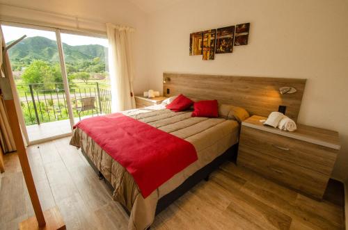 a bedroom with a large bed and a large window at Los Cóndores Aparts. in Villa General Belgrano