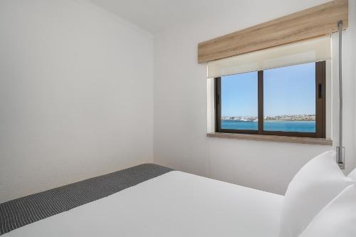 - une chambre avec un lit blanc et une fenêtre dans l'établissement Vista Rio - apartamento, à Portimão
