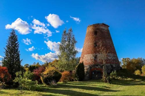 an old brick tower sitting on top of a field at Sodyba Prie Malūno in Žagarė
