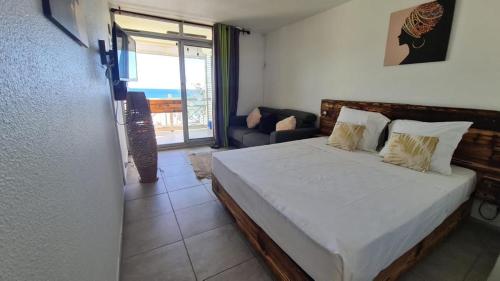 a bedroom with a bed with a view of the ocean at Perle marine Diamant in Le Diamant
