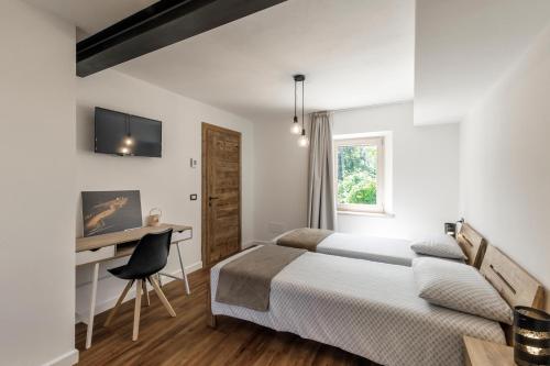Habitación de hotel con 2 camas y escritorio en Casa21 en SantʼAntonio Tortal