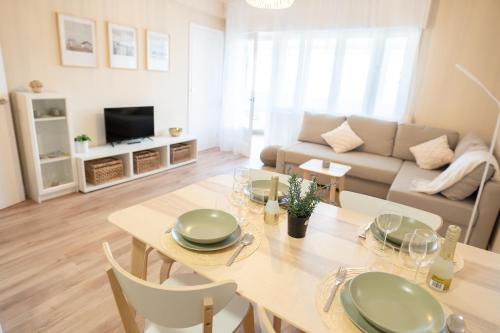 sala de estar con mesa y sofá en SAMIL PLAYA SUR, en Vigo