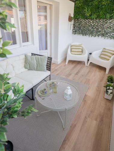a living room with a white couch and a table at SAMIL PLAYA SUR in Vigo