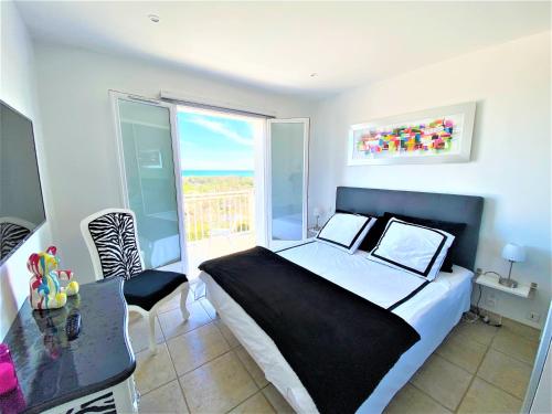 een slaapkamer met een bed en een tafel en een balkon bij Villa piscine avec magnifique vue mer panoramique in Biot
