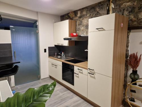 a kitchen with white cabinets and a refrigerator at Gîte Genius Loci in Marche-en-Famenne