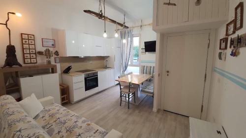 ein Wohnzimmer mit einem Sofa und eine Küche mit einem Tisch in der Unterkunft casa vacanza fronte mare Fano Sassonia 2 in Fano