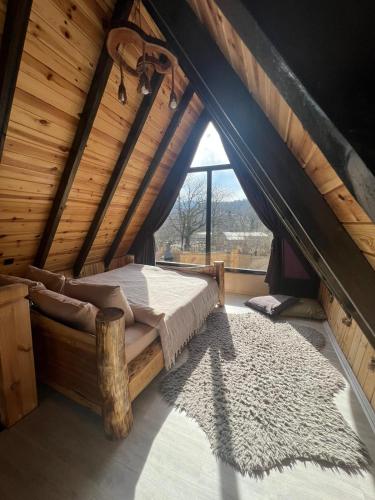 ein Schlafzimmer mit einem Bett im hölzernen Dachgeschoss in der Unterkunft Sapancamtbungalov in Sapanca