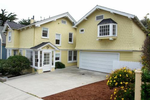 una casa amarilla con garaje blanco en 3118 Yellow House Main home en Pacific Grove
