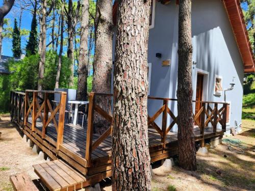 una casa con una gran terraza de madera junto a los árboles en Sueños de Mar en Balneario Mar Blau