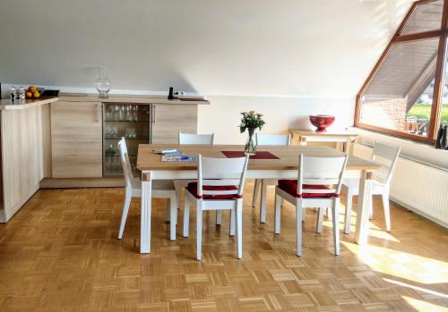 a kitchen and dining room with a wooden table and chairs at Ferienwohnungen Kapitänskajüte & Ausguck in Maasholm
