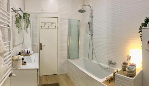 uma casa de banho branca com uma banheira e um chuveiro em Gemelli-San Pietro-Trastevere-casa con posto auto em Roma