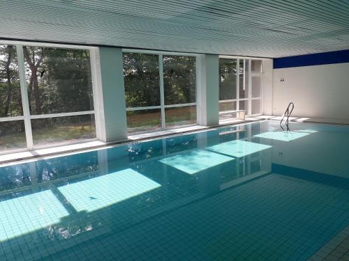 una gran piscina con ventanas en un edificio en Fewo-Heikenberg-mit-Schwimmbad, en Bad Lauterberg