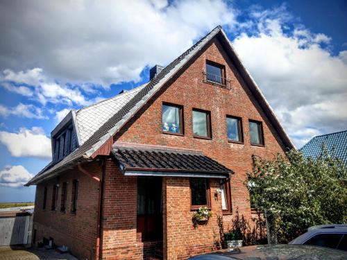 a red brick house with a gambrel roof at Ferienwohnungen Kapitänskajüte & Ausguck in Maasholm
